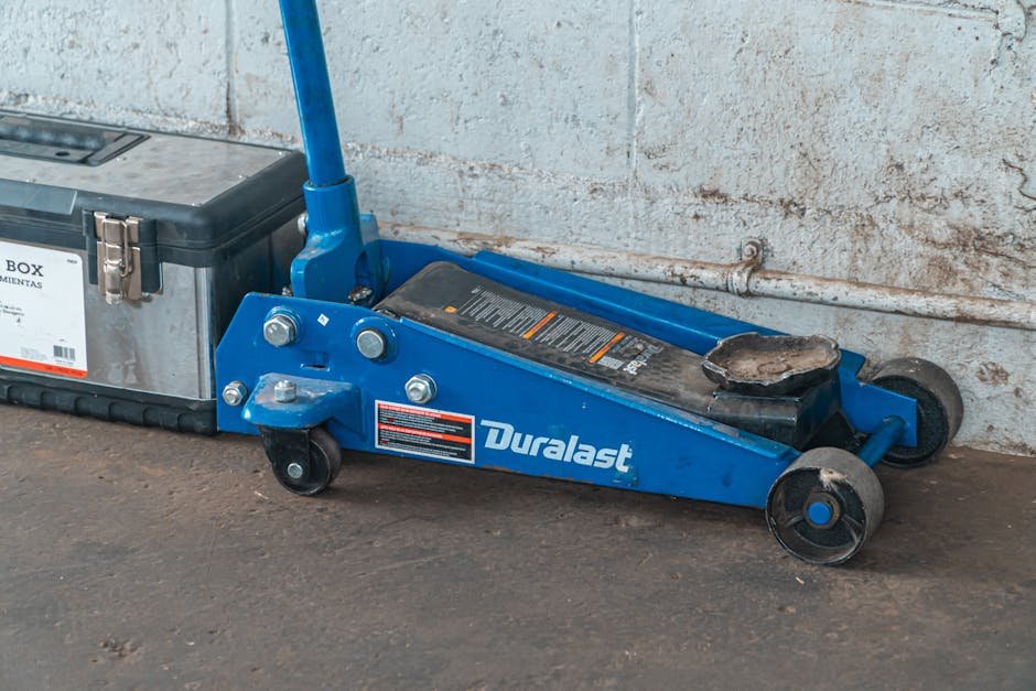 A close-up of a rubber EV jack pad being placed into the lifting point of an electric vehicle underbody