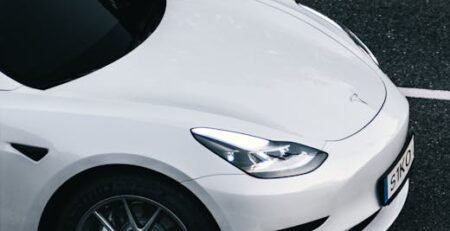 Close-up of premium aluminum and rubber EV pedal covers installed in a Tesla Model 3, showing the anti-slip surface and sleek design