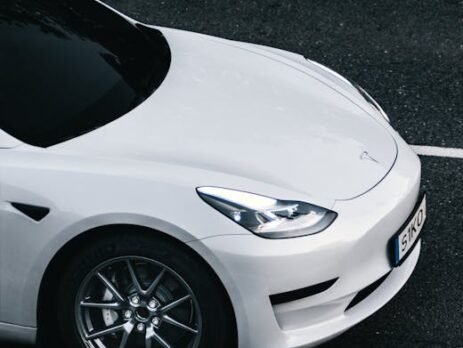 Close-up of premium aluminum and rubber EV pedal covers installed in a Tesla Model 3, showing the anti-slip surface and sleek design