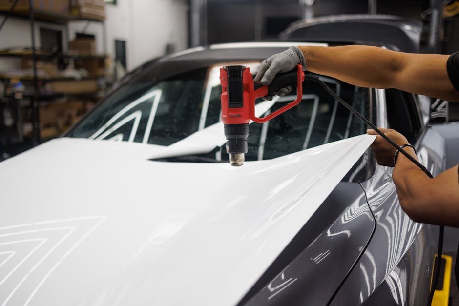 Close-up of a premium, multi-layer EV sunshade with a reflective silver coating being unrolled across the massive glass roof of a modern electric vehicle