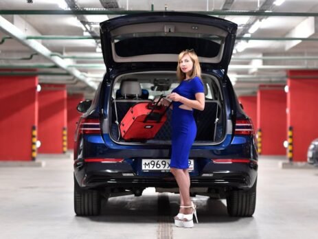 A heavy-duty, multi-compartment EV trunk organizer filled with charging cables, tools, and groceries, securely strapped in a Tesla Model Y